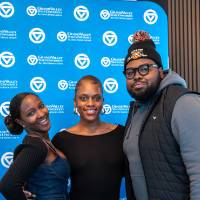 One man and two women standing in front of GV backdrop for photo
